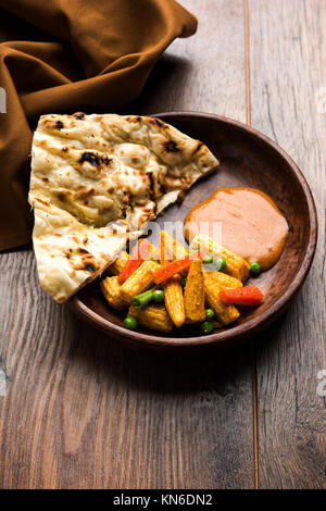 Bambino indiano Masala mais o piccante Baby corn curry servita con roti o naan o pane indiano Foto Stock