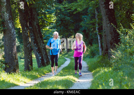 Due anziani attivi con uno stile di vita sano sorridere mentre joggin Foto Stock