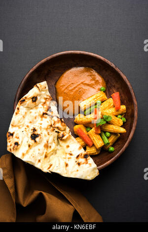 Bambino indiano Masala mais o piccante Baby corn curry servita con roti o naan o pane indiano Foto Stock