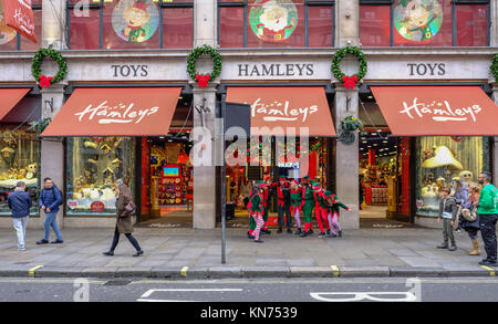 Regent Street, Londra, Regno Unito - 5 Dicembre 2017: gli elfi divertirsi al di fuori del negozio di giocattoli Hamleys in Regent Street. Il Natale di entusiasmo. Foto Stock