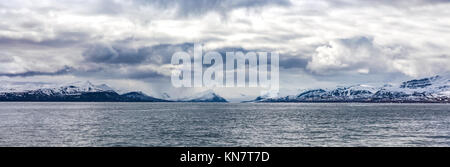 Panorama di nuvole sopra le montagne nevose nell'artico Foto Stock