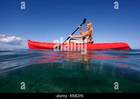 Sana e felice pale femmina in rosso di un kayak a Palauea, Maui, Hawaii. A livello diviso vista. Foto Stock