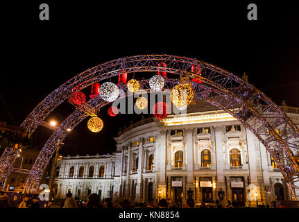 Vienna, Austria, 10 dicembre 2017. Il Burgtheater, incorniciato da ingresso illuminato caratteristica della tradizionale stagione festiva Mercatino di Natale in Piazza Municipale (Christkindlmarkt am Rathausplatz, Wiener Christkindlmarkt), il più grande mercato yuletide in Vienna, situato presso il Neues Rathaus (nuovo municipio) nel quartiere dei musei di Vienna centrale (Innere Stadt). Credito: Graham Prentice/Alamy Live News. Foto Stock