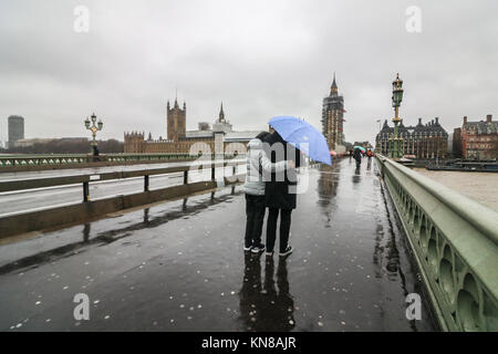 Londra, Regno Unito. Undicesimo Dec, 2017. Londra di Mattina pendolari battaglia il freddo Pioggia gelata, alta venti pioggia e grandine sul Westminster Bridge in ciò che è noto come Black Ice lunedì un giorno dopo la prima nevicata nella capitale. Il Met Office ha emesso gli avvisi di ambra per significative nevicate in molte parti del Regno Unito con il rischio di gravi perturbazioni al credito di viaggio: amer ghazzal/Alamy Live News Foto Stock