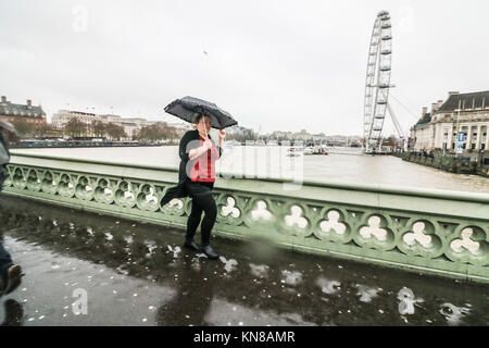 Londra, Regno Unito. Undicesimo Dec, 2017. Londra di Mattina pendolari battaglia il freddo Pioggia gelata, alta venti pioggia e grandine sul Westminster Bridge in ciò che è noto come Black Ice lunedì un giorno dopo la prima nevicata nella capitale. Il Met Office ha emesso gli avvisi di ambra per significative nevicate in molte parti del Regno Unito con il rischio di gravi perturbazioni al credito di viaggio: amer ghazzal/Alamy Live News Foto Stock