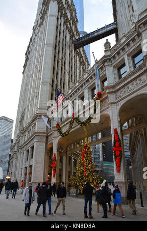 Chicago, Stati Uniti d'America. Decimo Dec, 2017. Gli acquirenti di vacanza su Michigan Avenue's 'Magnificent Mile' a piedi passato le luci di Natale sul Wrigley Building su un vivace serata in Chicago. Credito: D Valutazione Smith/Alamy Live News Foto Stock