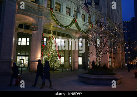 Chicago, Stati Uniti d'America. Decimo Dec, 2017. Gli acquirenti di vacanza su Michigan Avenue's 'Magnificent Mile' a piedi passato le luci di Natale sul Wrigley Building su un vivace serata in Chicago. Credito: D Valutazione Smith/Alamy Live News Foto Stock