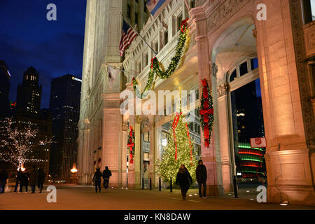 Chicago, Stati Uniti d'America. Decimo Dec, 2017. Gli acquirenti di vacanza su Michigan Avenue's 'Magnificent Mile' a piedi passato le luci di Natale sul Wrigley Building su un vivace serata in Chicago. Credito: D Valutazione Smith/Alamy Live News Foto Stock