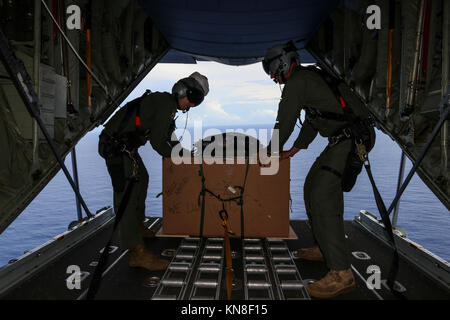 Loadmasters con la Royal Australian Air Force preparare a airdrop un fascio di forniture su un isola micronesiana durante il funzionamento 66caduta di Natale 10 dicembre 2017. Ogni dicembre americani e australiani C-130 Hercules equipaggi airlift cibo, forniture e giocattoli per gli isolani in tutta Micronesia. Foto Stock