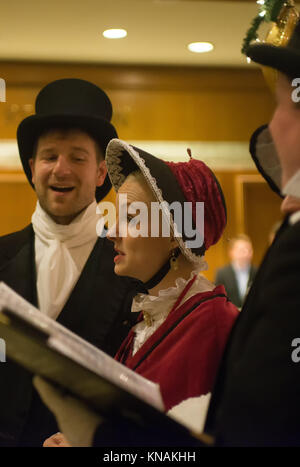 Gruppo di persone in costumi tradizionali cantare i canti natalizi presso il Fairmont Olympic Hotel Seattle Washington Foto Stock