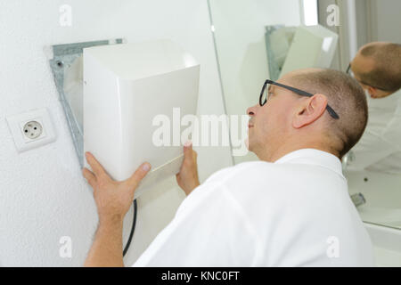 Uomo che ripara un essiccatore rotto Foto Stock