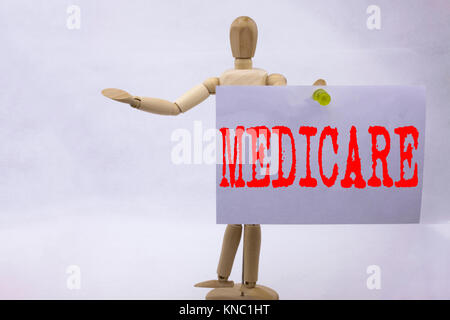 Mano concettuale di scrittura di testo Didascalia ispirazione mostra Medicare la concezione di business per una completa assicurazione medica salute piano scritto una nota adesiva Foto Stock