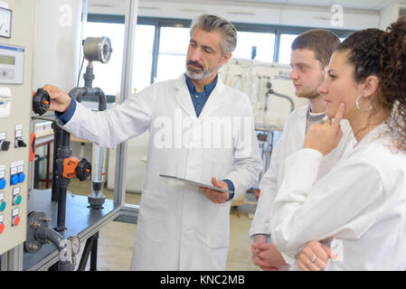 Gli studenti guardando insegnante dimostrando attrezzature Foto Stock