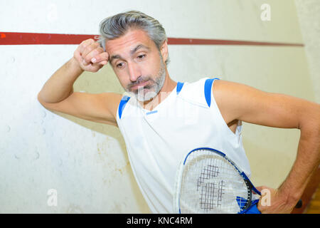 Giocatore di squash cercando esaurito Foto Stock