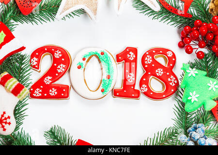 Ghirlanda di Natale con decorazioni con pan di zenzero 2018, ramo di albero di Natale su sfondo bianco. Un simbolo di inverno e le vacanze di capodanno. Foto Stock