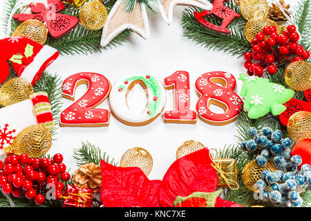 Ghirlanda di Natale con decorazioni con pan di zenzero 2018, ramo di albero di Natale su sfondo bianco. Un simbolo di inverno e le vacanze di capodanno. Foto Stock