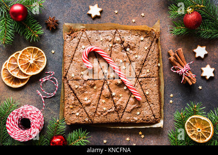 Brownie al cioccolato con la caramella di canna da zucchero e le decorazioni di Natale. Vista dall'alto. Dolce vacanza invernale cibo Foto Stock