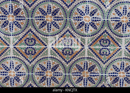Close up di un variopinto mosaico di mattonelle a parete con arancione, verde, blu e piastrelle bianche e marroni e bianchi boiacca. Esso ha un decoro floreale. Foto Stock