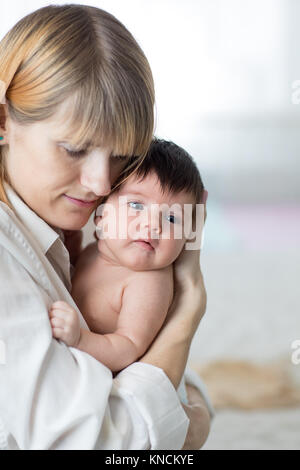 Madre abbracciando baby Foto Stock