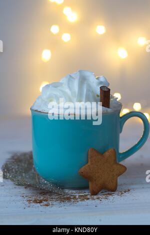 Cioccolata calda con panna e stella gingerbread su un sfondo bokeh di fondo Foto Stock