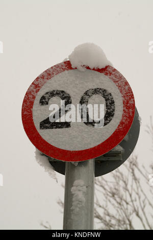 20 km/h il limite massimo di velocità cartello stradale oscurata dalla neve Foto Stock