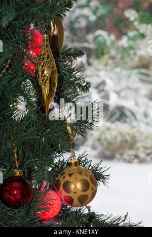 christmas tree decorations snow in garden baubles lights Foto Stock
