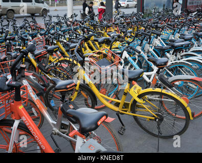 Wuhan Hubei Cina, 10 Dicembre 2017: Partite di bike sharing di diverse marche closeup con il logo della compagnia di Mobike Hellobike e Ofo Foto Stock