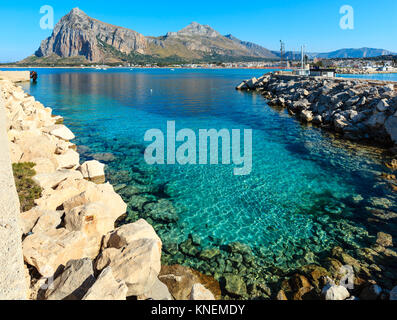 San Vito lo Capo beach con chiare acque azzurre e Monte Monaco nel lontano nord-occidentale della Sicilia, Italia. Persone irriconoscibile. Foto Stock