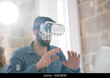 Imprenditore indossando la realtà virtuale auricolare in carica Foto Stock