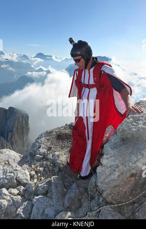 Wingsuit maschio a ponticello di base si prepara a volare da cliff edge Foto Stock