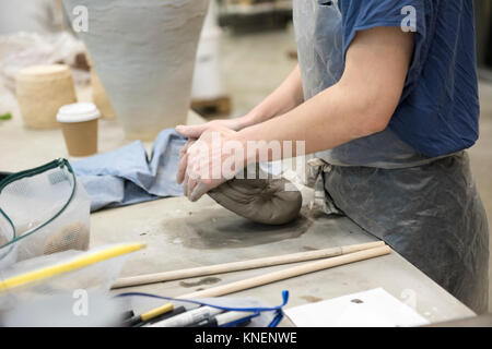 Vista ritagliata della donna in art studio di argilla per impastare Foto Stock