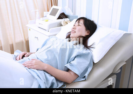 Donna incinta giacente in letto di ospedale Foto Stock
