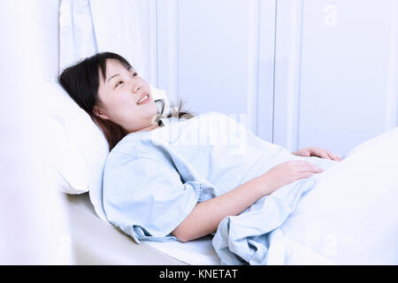 Donna incinta giacente in letto di ospedale Foto Stock