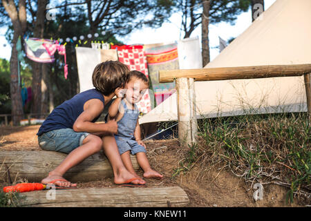 Bimbi maschio baciato sulla guancia dal suo grande fratello in campeggio Foto Stock