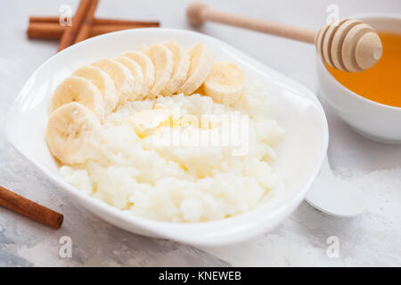 Farinata di Riso con burro, miele, banana e cannella. Colazione sana nozione di porridge. Foto Stock