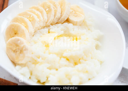 Farinata di Riso con burro, miele, banana e cannella. Colazione sana nozione di porridge. Foto Stock