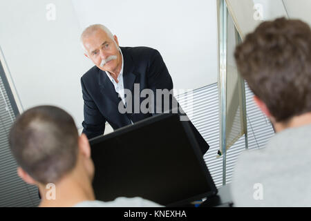 Insegnante in piedi di fronte a studenti in aula Foto Stock