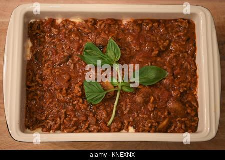La cottura del cibo fotografia immagine di un piatto di carne italiana la pasta le lasagne con le foglie di basilico per una famiglia pasto serale o cena Foto Stock