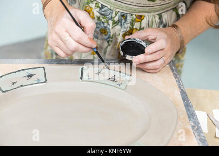 Potter motivi di pittura sul piatto da portata Foto Stock