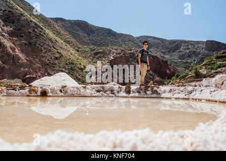 L'uomo esplorare Maras miniere di sale, Cusco, Perù, Sud America Foto Stock