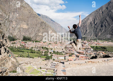 Uomini Salto in alto delle rovine di Ollantaytambo, Cusco, Perù, Sud America Foto Stock
