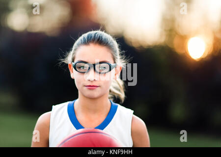 Ritratto di una ragazza che indossa gli occhiali sportivi Pallacanestro di contenimento Foto Stock