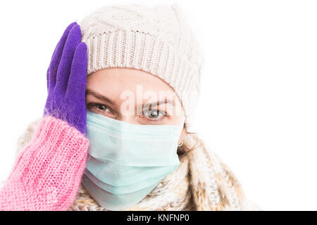 Uno stato di malessere donna che mantiene la sua testa a causa dell'inverno virus influenzale e indossare Caldo berretto lavorato a maglia e sciarpa Foto Stock