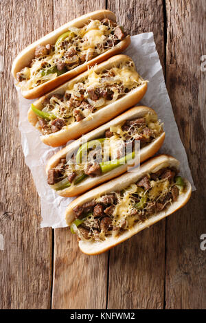 Deliziosi panini cheesesteak close-up su carta sul tavolo. Verticale in alto vista da sopra Foto Stock