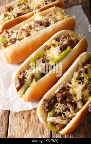 Deliziosi panini cheesesteak close-up su carta su tavola verticale. Foto Stock