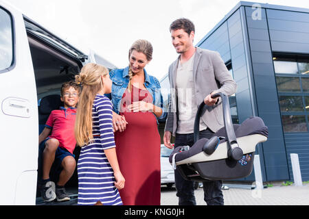 Il controllo della famiglia nuova auto in concessionaria auto Foto Stock