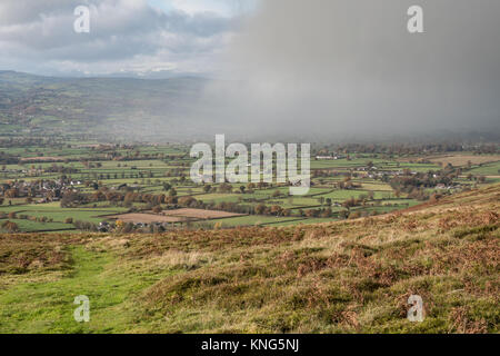Una doccia a pioggia si sposta attraverso la valle al di sotto della gamma Clwydian delle colline vicino a Moel Famau nel Galles del Nord. Il Galles, Regno Unito. Foto Stock