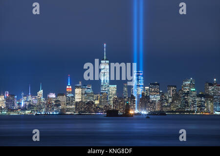 Le due travi del tributo in luce con skycrapers di Lower Manhattan di notte dal Porto di New York. Il quartiere finanziario di New York City Foto Stock