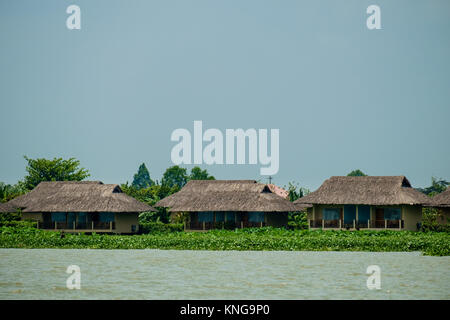 Case dal tetto di paglia lungo il fiume Mekong Foto Stock