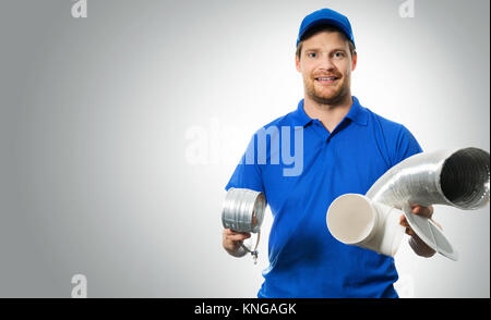 Lavoratore hvac con sistema di ventilazione apparecchiature in mani su sfondo grigio Foto Stock